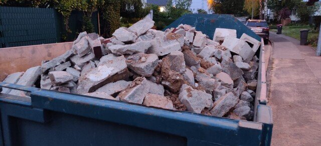 Mit Beton- und Mauerwerksbruch beladener Container